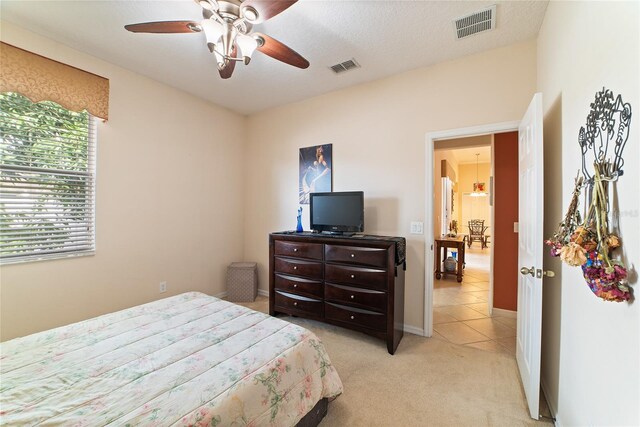 carpeted bedroom featuring a textured ceiling and ceiling fan