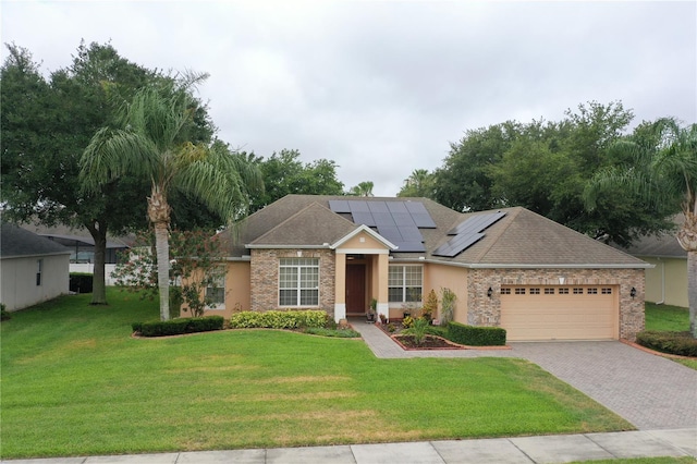 ranch-style house with a garage, solar panels, and a front lawn