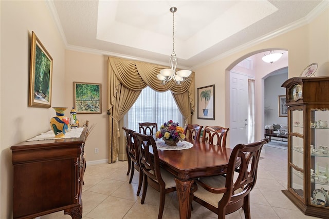 dining room featuring an inviting chandelier, a raised ceiling, ornamental molding, and light tile patterned flooring