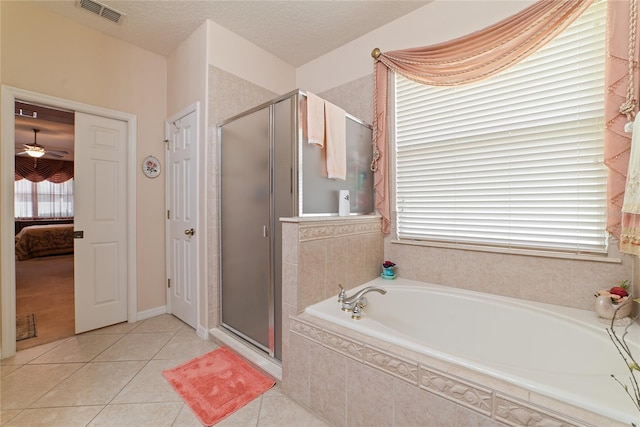 bathroom with ceiling fan, a textured ceiling, tile patterned flooring, and a wealth of natural light