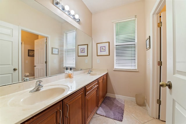 bathroom with a healthy amount of sunlight, vanity, toilet, and tile patterned floors