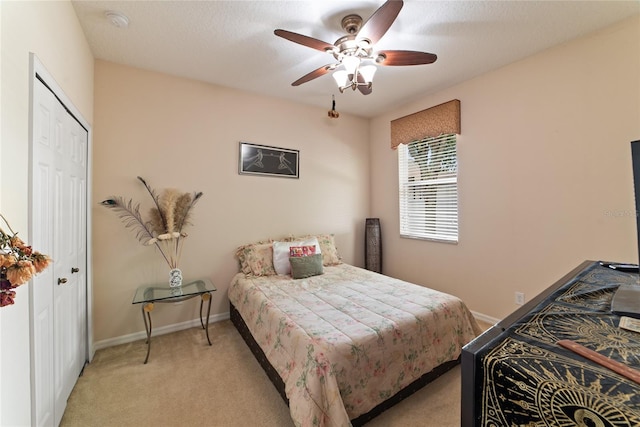 carpeted bedroom featuring a textured ceiling, ceiling fan, and a closet