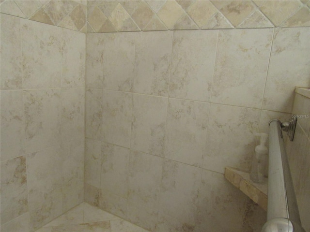 interior details featuring a tile shower