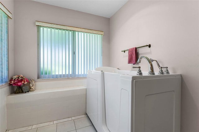 bathroom with tile floors, plenty of natural light, and a bath to relax in