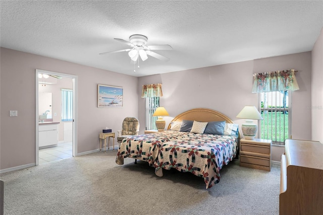 carpeted bedroom featuring ceiling fan, a textured ceiling, and ensuite bathroom