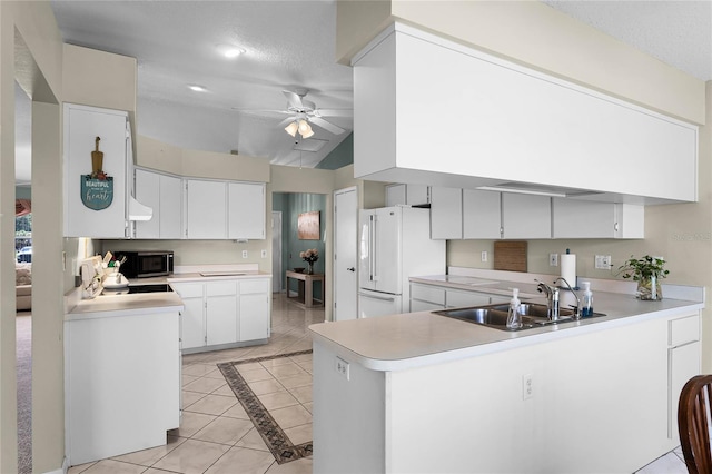 kitchen with ceiling fan, vaulted ceiling, kitchen peninsula, and sink