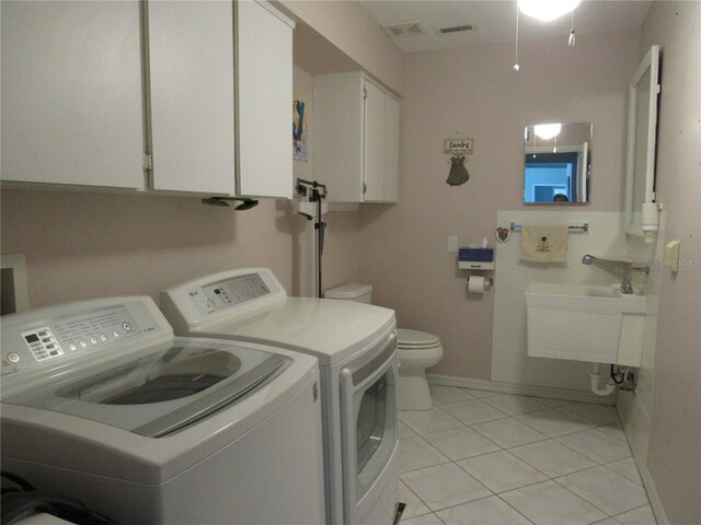 washroom with sink, washing machine and clothes dryer, and light tile flooring