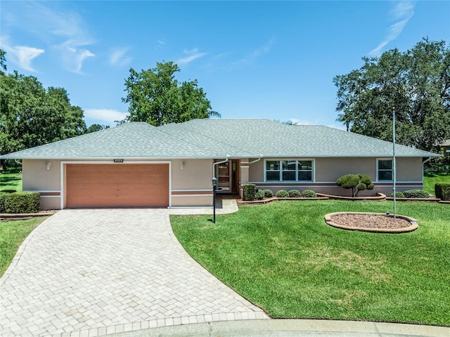 ranch-style house featuring a garage and a front lawn