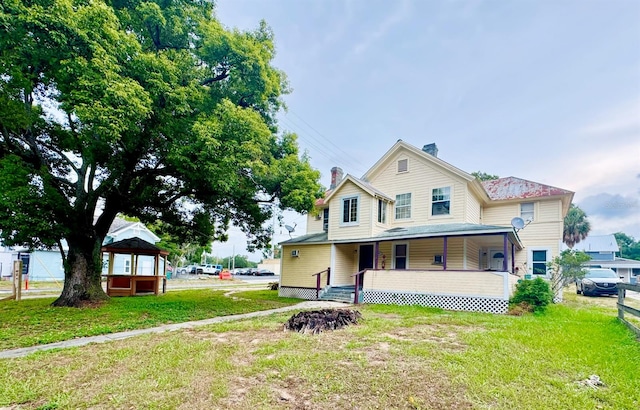 view of front of house featuring covered porch and a front lawn