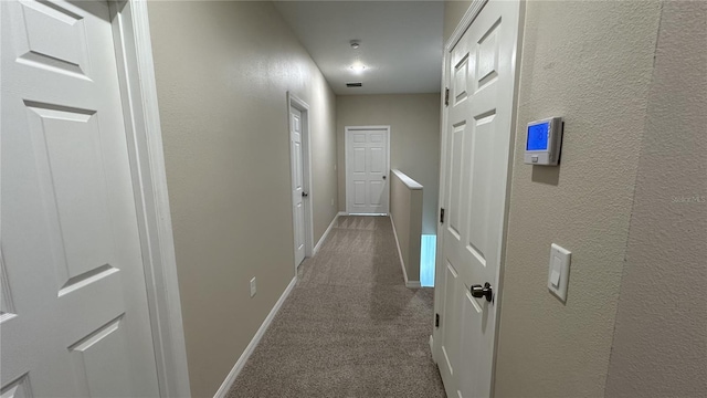 hallway with dark colored carpet