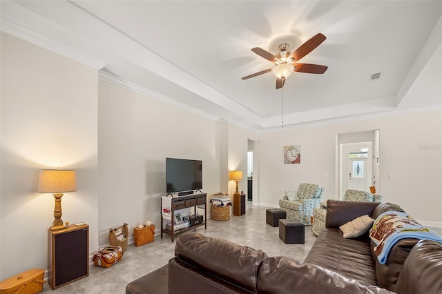 tiled living room featuring ornamental molding, ceiling fan, and a raised ceiling