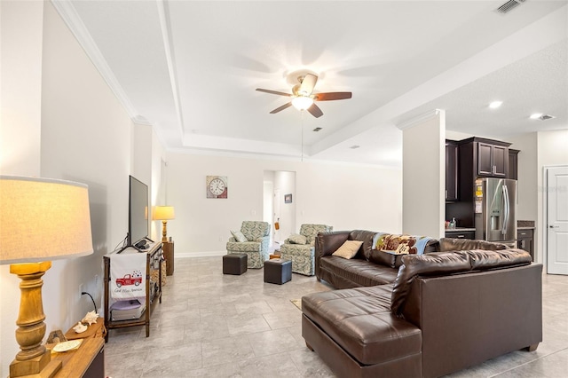 living room featuring a raised ceiling, ornamental molding, ceiling fan, and light tile flooring