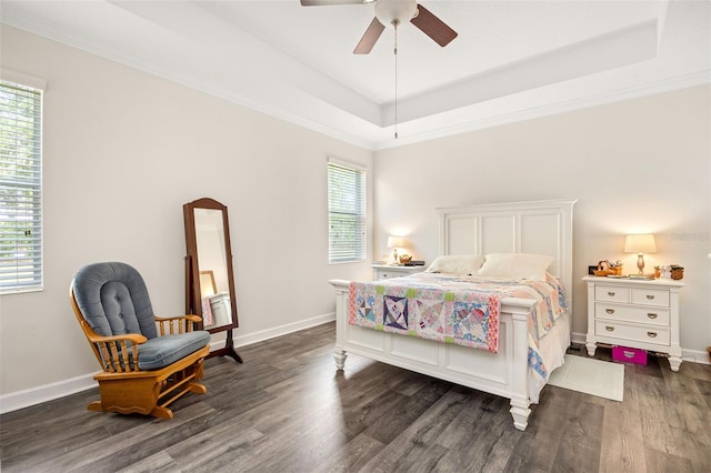 bedroom featuring a tray ceiling, crown molding, ceiling fan, and dark hardwood / wood-style flooring