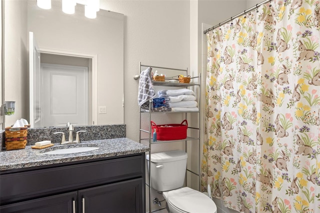 bathroom featuring vanity with extensive cabinet space and toilet