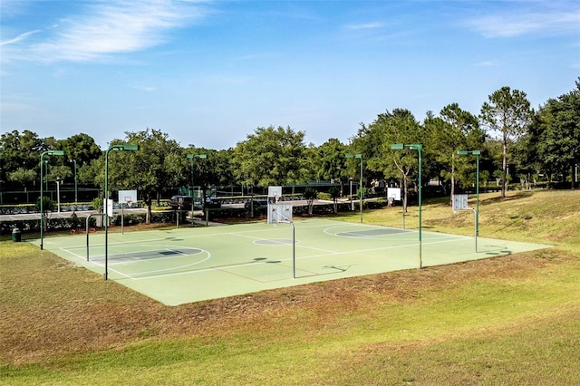 view of sport court with a lawn