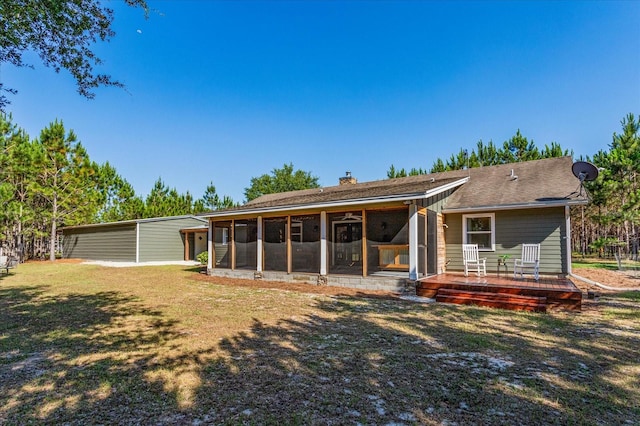 rear view of property featuring a lawn and a sunroom