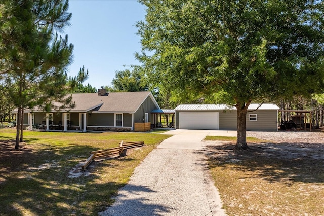 single story home with an outbuilding, a garage, and a front yard