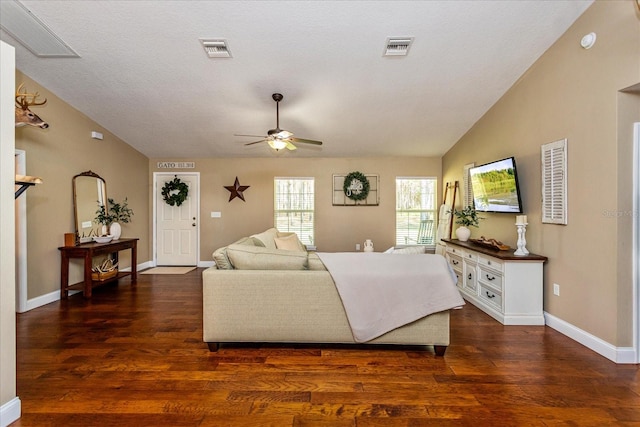 living room with dark wood-type flooring, ceiling fan, lofted ceiling, and a textured ceiling