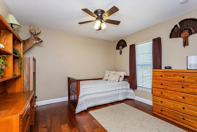 bedroom with dark wood-type flooring, a textured ceiling, and ceiling fan