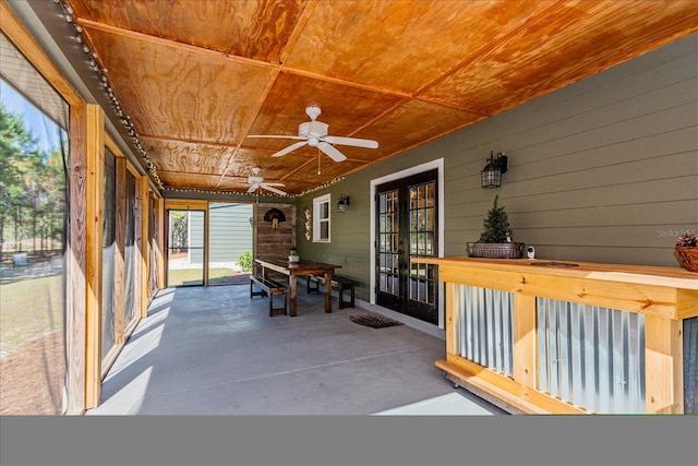 unfurnished sunroom with ceiling fan, wood ceiling, and french doors