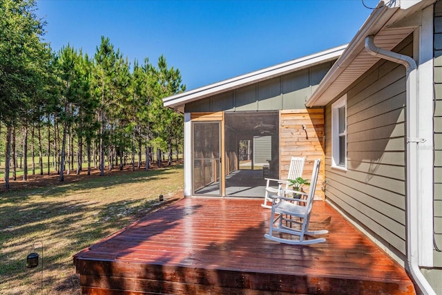 wooden terrace with a yard and a sunroom