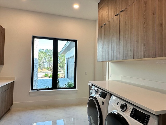 laundry area with cabinets and washing machine and clothes dryer