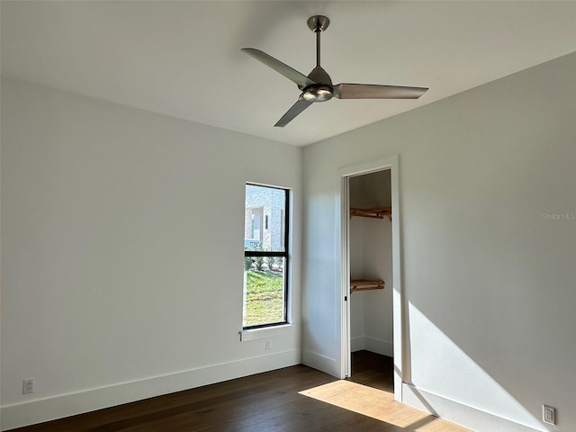 unfurnished bedroom with dark hardwood / wood-style floors, ceiling fan, and a closet