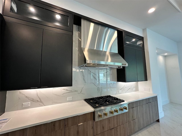 kitchen featuring backsplash, stainless steel gas stovetop, and wall chimney range hood