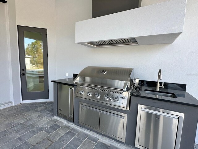 view of patio featuring exterior kitchen, sink, and grilling area