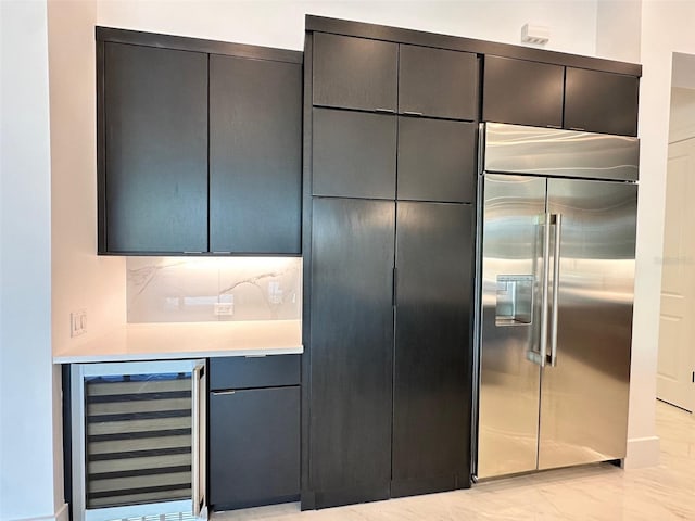 kitchen with decorative backsplash, beverage cooler, and stainless steel built in refrigerator