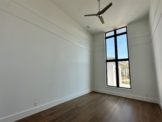 empty room with ceiling fan and dark hardwood / wood-style floors