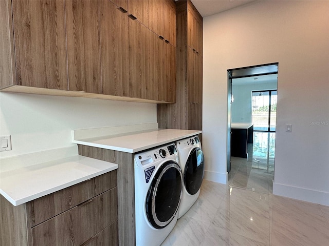 clothes washing area with washing machine and dryer and cabinets