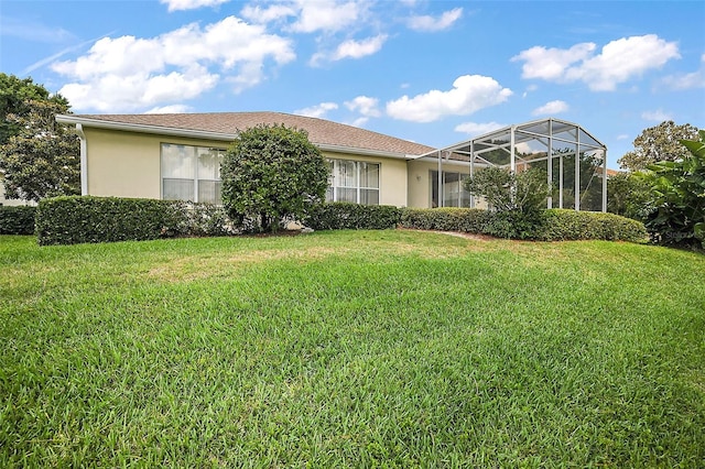 view of front facade with glass enclosure and a front lawn