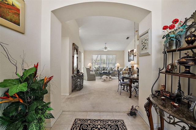 corridor with light colored carpet and vaulted ceiling