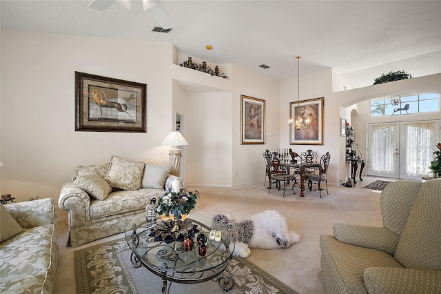 living room with carpet, vaulted ceiling, a textured ceiling, and french doors