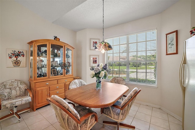 dining room with a notable chandelier, light tile patterned floors, a textured ceiling, and a wealth of natural light