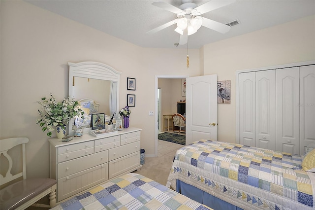 bedroom with ceiling fan, a closet, and light carpet