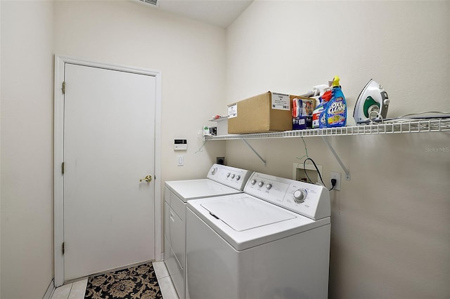 laundry room with light tile patterned floors and washer and clothes dryer