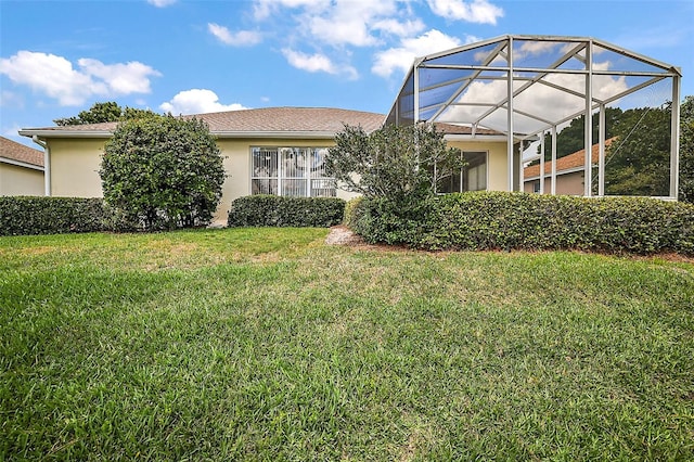 exterior space featuring a front lawn and glass enclosure