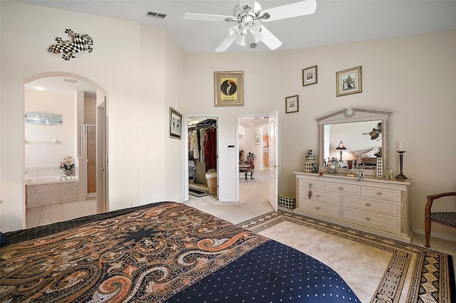 bedroom with a closet, ensuite bathroom, ceiling fan, and light tile patterned flooring