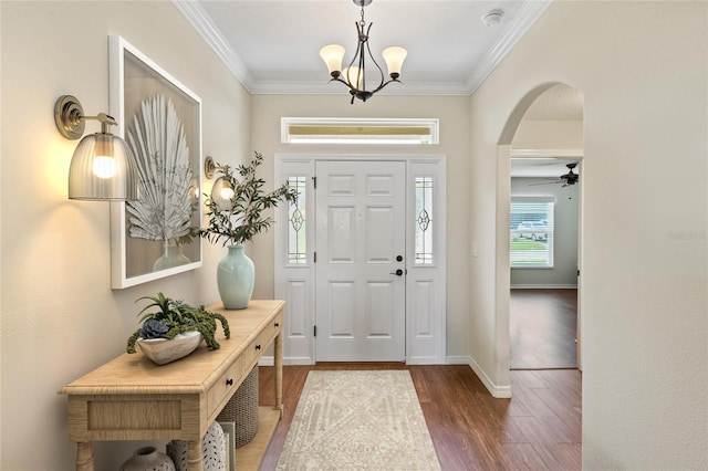 entrance foyer featuring ceiling fan with notable chandelier, dark hardwood / wood-style flooring, and crown molding