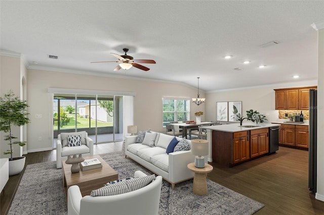 living room featuring dark hardwood / wood-style floors, ornamental molding, sink, and ceiling fan with notable chandelier