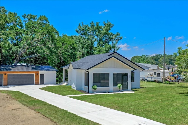 modern farmhouse style home featuring a front lawn and a garage