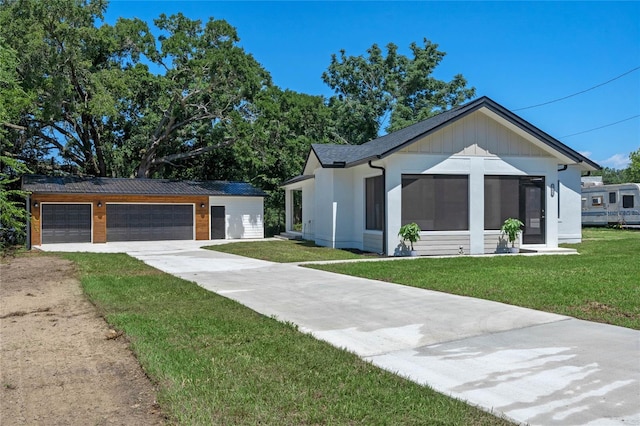 modern inspired farmhouse featuring a front lawn and a garage