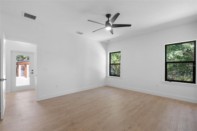 unfurnished room with a wealth of natural light, ceiling fan, and hardwood / wood-style floors