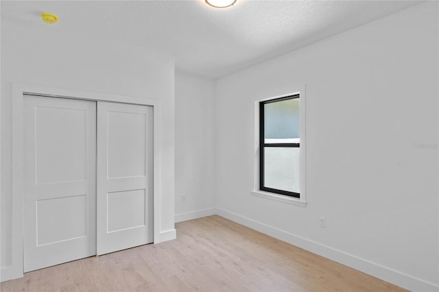 unfurnished bedroom with a closet and light hardwood / wood-style flooring