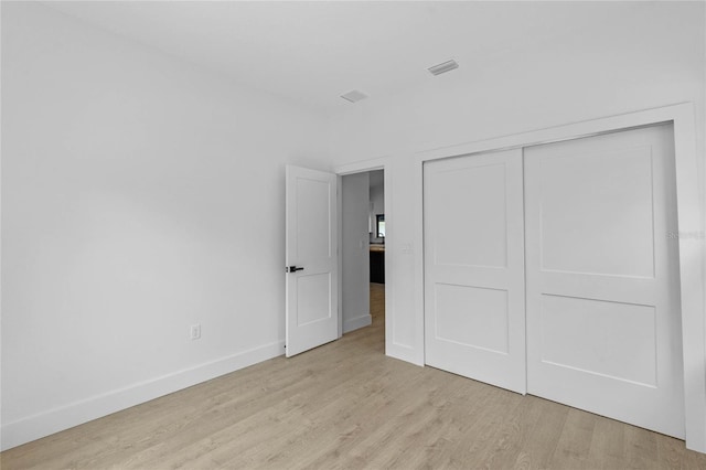 unfurnished bedroom featuring a closet and light hardwood / wood-style floors