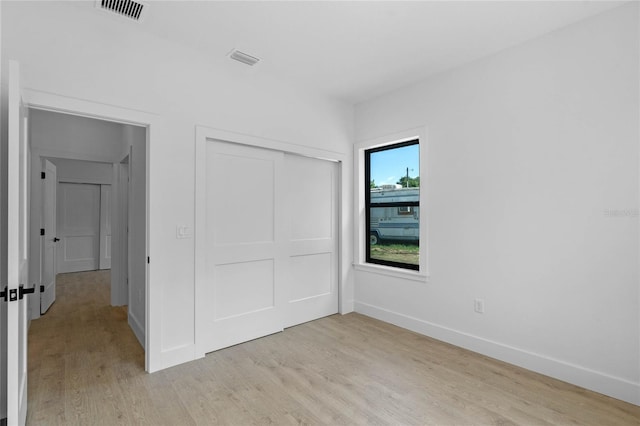 unfurnished bedroom featuring a closet and light hardwood / wood-style flooring