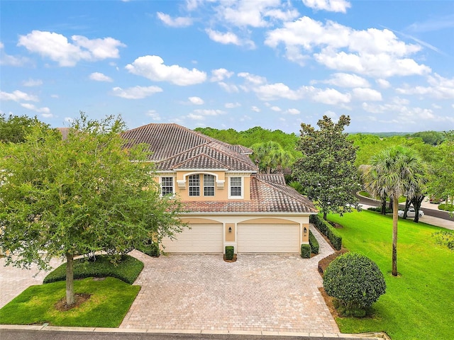 mediterranean / spanish home with a garage and a front yard