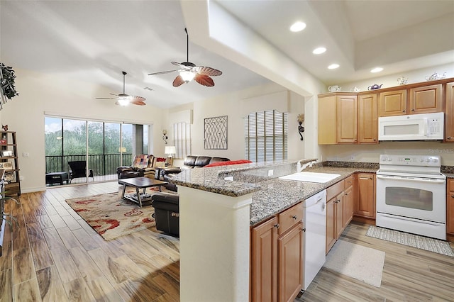 kitchen featuring sink, white appliances, light hardwood / wood-style flooring, stone counters, and kitchen peninsula